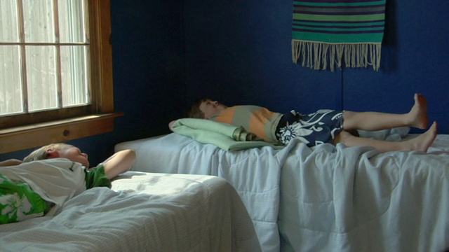 美国马萨诸塞州特鲁罗，两个男孩(8- 9,10 -11)躺在小屋里的床上视频下载