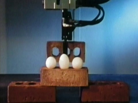1984年，中景机器人手臂在砖块上移动砖块视频素材
