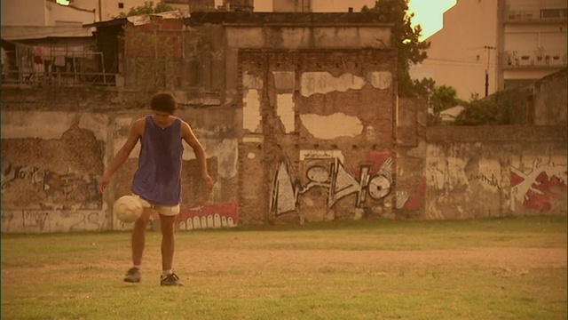 SLO MO, PAN, WS，男人在球场上踢足球在日落，布宜诺斯艾利斯，阿根廷视频素材