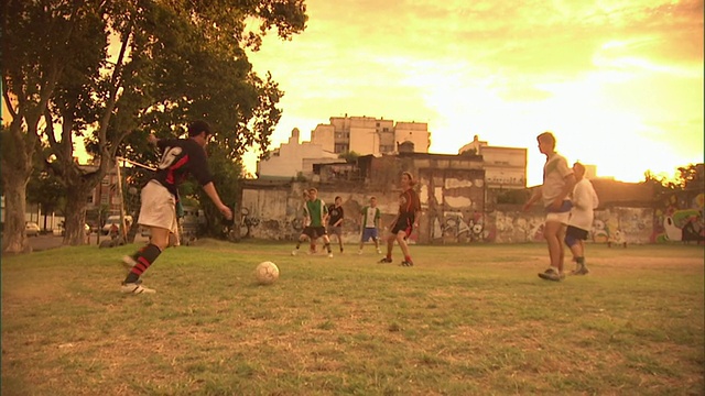 SLO MO, MS, PAN，男人踢足球在日落，布宜诺斯艾利斯，阿根廷视频素材