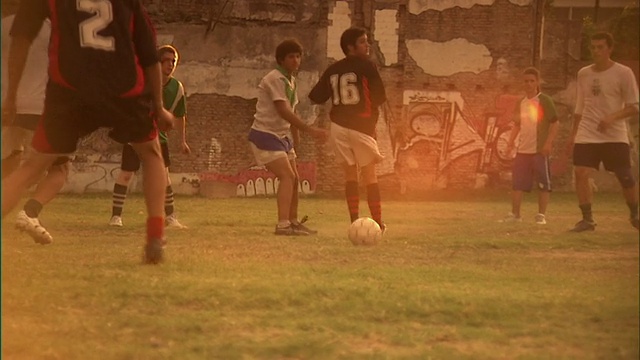 SLO MO, MS, PAN，男人踢足球在日落，布宜诺斯艾利斯，阿根廷视频素材