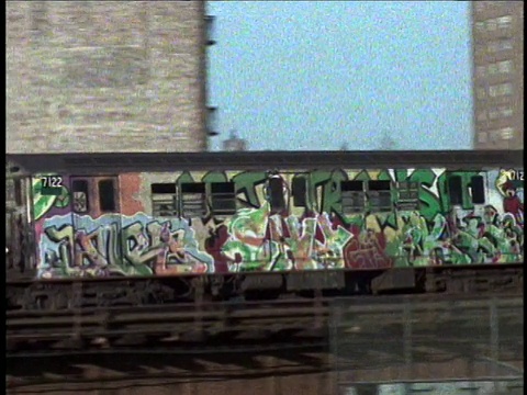 20世纪70年代，美国纽约，涂满涂鸦的高架地铁经过公寓大楼视频下载