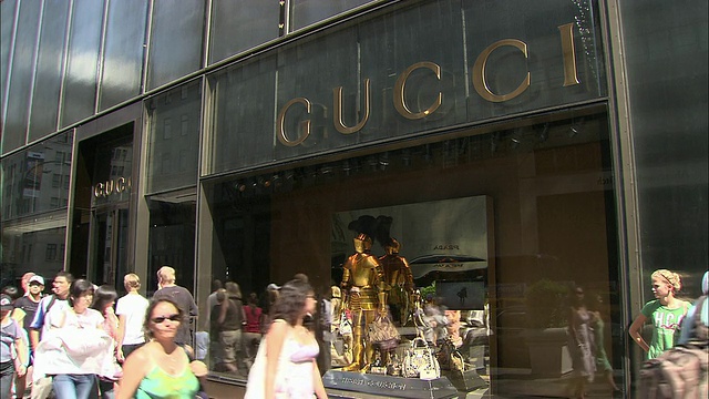美国纽约市，第五大道，路过古琦商店橱窗的行人视频下载