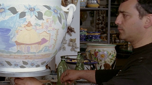 意大利坎帕尼亚的普拉亚诺/阿马尔菲海岸的手工艺人在车间里画陶瓷花瓶视频下载