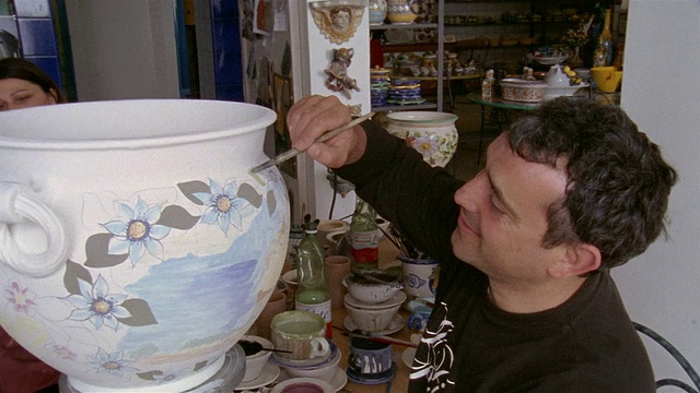高角度近距离艺术家绘画陶瓷花瓶在工作室在普拉亚诺/阿马尔菲海岸，坎帕尼亚，意大利视频下载