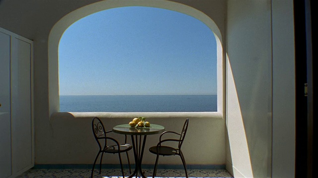 中镜头的桌子和椅子在壁龛露台俯瞰萨莱诺湾/普拉亚诺，阿马尔菲海岸，意大利视频下载