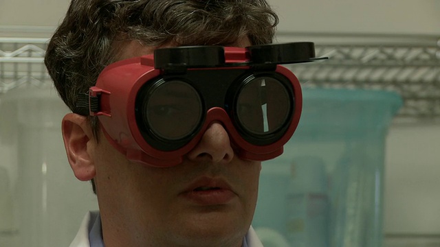 科学家戴着护目镜观察光爆炸，亚特兰大，乔治亚，美国视频下载