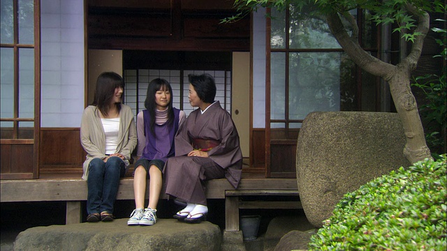 日本东京，祖母，母亲和十几岁的女孩并排坐在门口视频素材