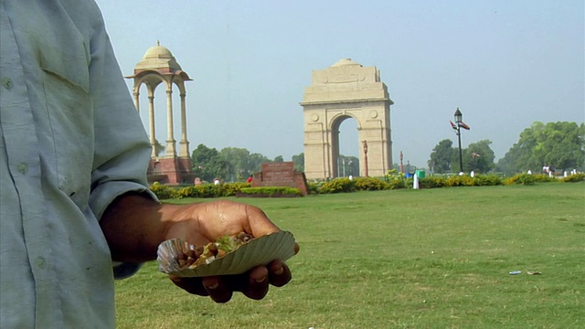 印度新德里，男子正在准备Chole bhature，手的特写，背景中的印度门视频素材
