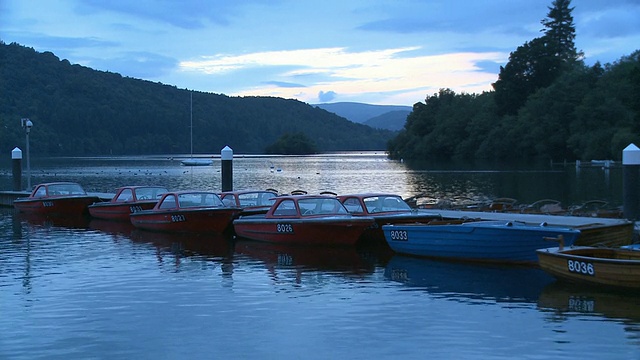 英国坎布里亚郡，黄昏时分，小船停泊在温德米尔湖上视频下载