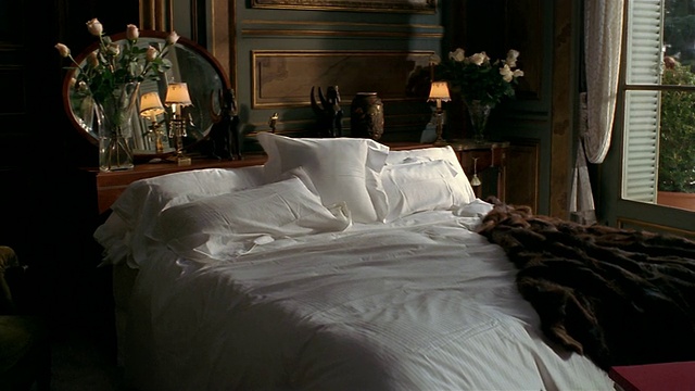 宽镜头的卧室内部与裘皮大衣扔在床上视频素材