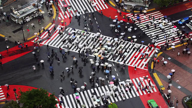 时间延时高角度广角拍摄的交通和行人撑着雨伞在涉谷十字路口/东京视频下载