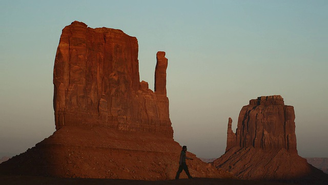 WS，男人的剪影通过东Mitten和西Mitten在日落，纪念碑谷，美国亚利桑那州视频素材