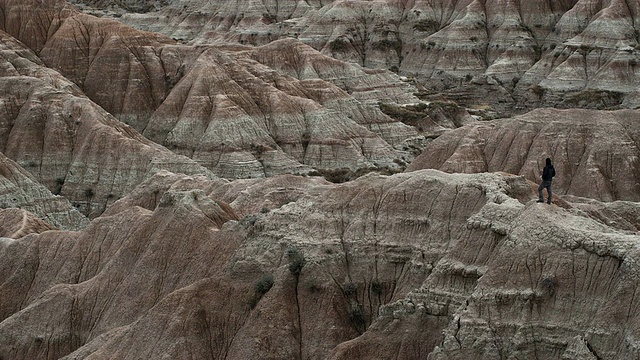 WS, PAN，在美国南达科他的Badlands国家公园，男人的剪影站在岩层上视频素材