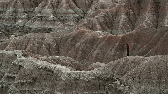 美国南达科他州Badlands国家公园的岩石上行走的男子视频素材