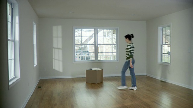 美国新泽西州，普莱恩菲尔德，一名妇女在空房间里提着纸板箱视频素材