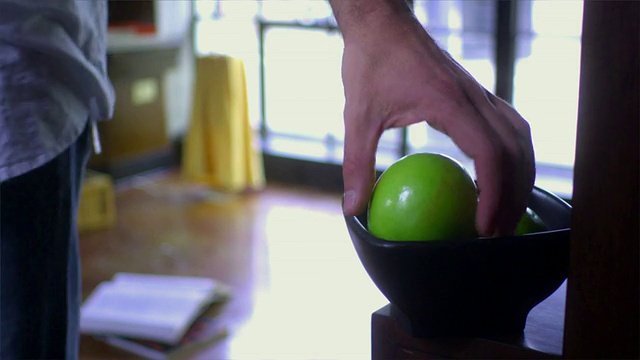 SLO MO，选择性对焦，人抓取相机，聚焦在前景碗里的苹果，在美国加州圣地亚哥附近视频下载