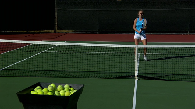 SLO MO, WS，年轻女子打网球，网球机射击在前景，圣巴巴拉，加州，美国视频下载