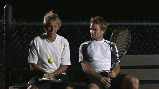 MS，两个年轻的网球运动员坐在网球场的长椅上聊天，晚上，圣巴巴拉，加利福尼亚，美国视频素材
