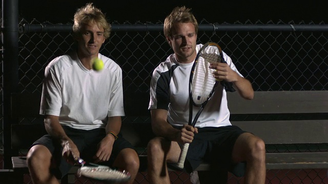 MS, TU，两个年轻的网球运动员坐在网球场的长椅上聊天，晚上，圣巴巴拉，加利福尼亚，美国视频素材