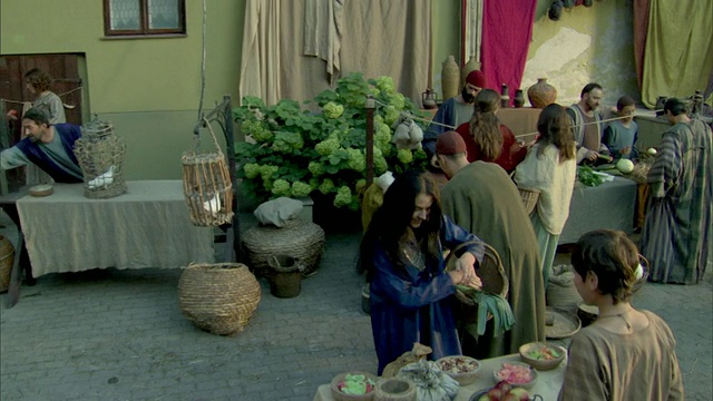 立陶宛维尔纽斯，中世纪露天市场，两个男人从阳台向楼下的男人扔面包视频素材