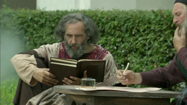 立陶宛维尔纽斯，中世纪男人坐在院子里写作和阅读的重演视频下载