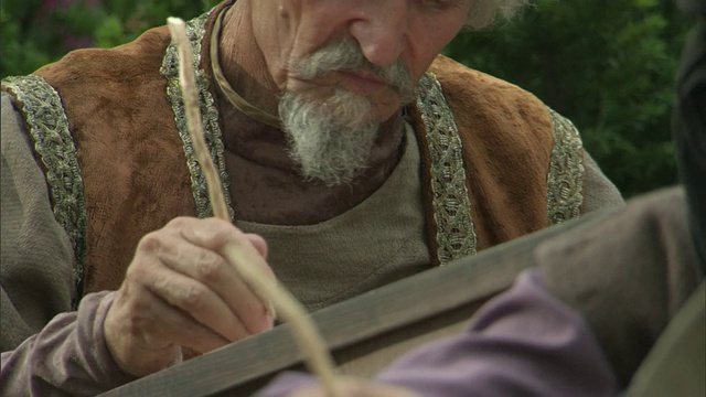 立陶宛维尔纽斯，中世纪男人坐在院子里口述男人写作的重演视频下载