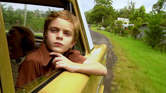 澳大利亚昆士兰州布里斯班的Tamborine山，男孩(6-7)透过车窗向外看，女孩(10-11)在后面视频下载