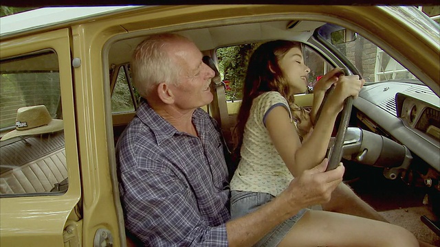 MS，祖父和孙女(10-11)假装开车，Tamborine山，布里斯班，昆士兰州，澳大利亚视频下载