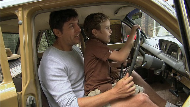 MS，父亲和儿子(6-7)假装开车，Tamborine山，布里斯班，昆士兰州，澳大利亚视频下载