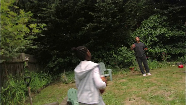 父亲在后院与儿子和女儿玩抛球视频素材