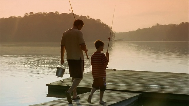 中等射击的父子带着鱼竿到码头的尽头/克拉克斯维尔，乔治亚州视频素材