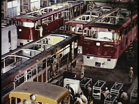 1963年蒙太奇工厂内部用装配线生产轨道车;起重机将火车车厢装载到货船/日本视频素材