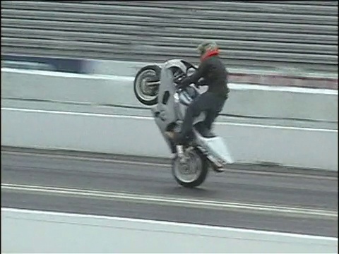MS, PAN, SHAKY，男子在赛道上做摩托车前轮着地，然后撞车，美国视频下载