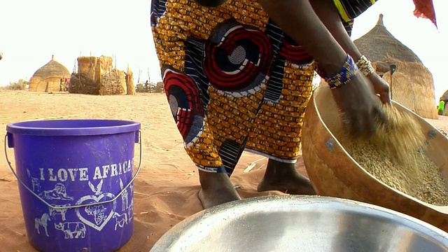 尼日尔尼亚美，一名女子在碗里搅拌小米视频素材