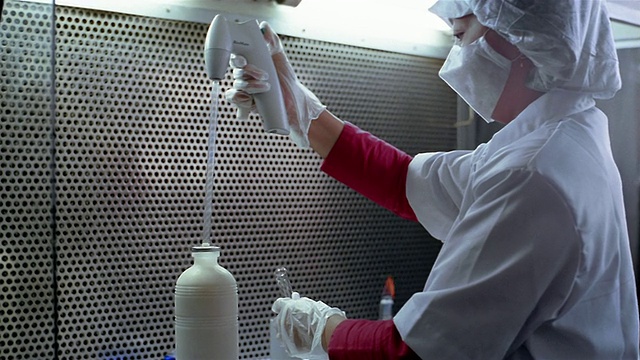 中等剂量的研究人员从容器中提取牛奶，并把它放在实验室的试管中视频素材