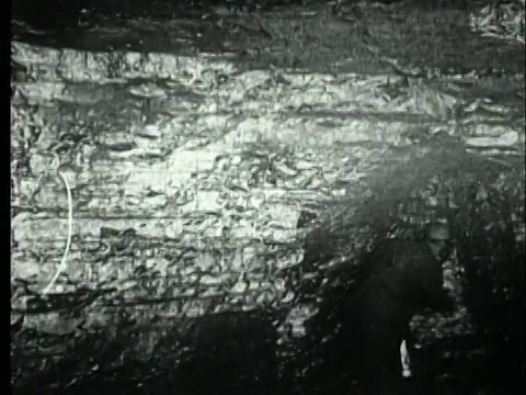 1927年，美国宾夕法尼亚州，B/W MS煤矿工人用安全灯和镐检查准备炸药的采煤工作面视频素材