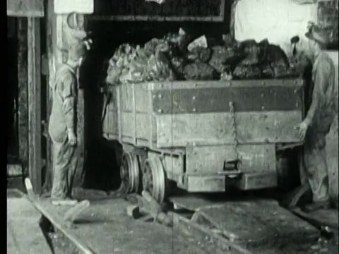1927年，美国宾夕法尼亚州，煤矿工人搬运装满烟煤的矿车准备卸货视频素材