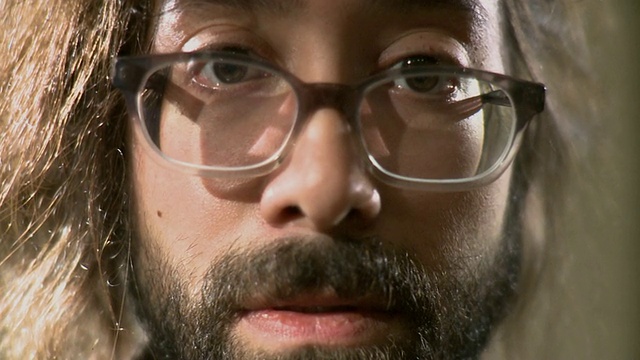 ECU的肖像男子戴眼镜和胡子在工作室视频素材