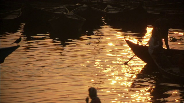 孟加拉国达卡，日落时分，一名男子推着他的船视频素材