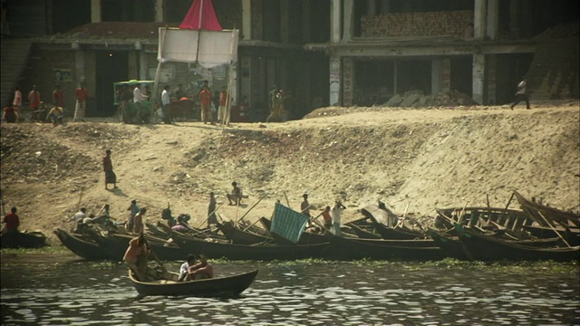 孟加拉国达卡，布里甘加河上的船只，人们在破败的河岸上行走视频素材