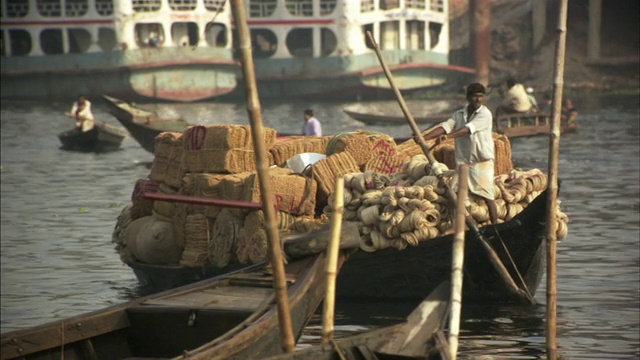 孟加拉国达卡，人们在河上用船运送门垫和纱线视频素材