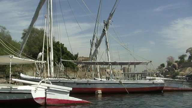沿着尼罗河行驶，经过停泊在埃及阿斯旺的小帆船视频素材