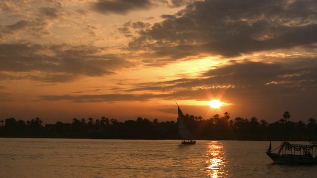 日落时分，埃及尼罗河上小帆船的剪影视频素材