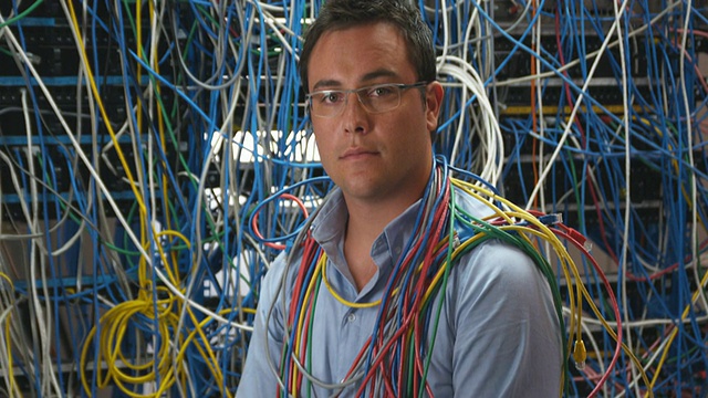 MS ZI男子的肖像脖子上绕着电缆，前面的服务器被电缆覆盖，悉尼，澳大利亚视频下载