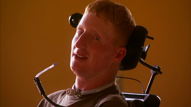 带头部支架和轮椅转向喉舌的四肢瘫痪青年男子的CU肖像/新斯科舍省哈利法克斯视频下载