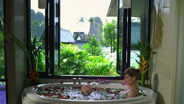 泰国甲米，女士在玫瑰花瓣温泉沐浴视频素材