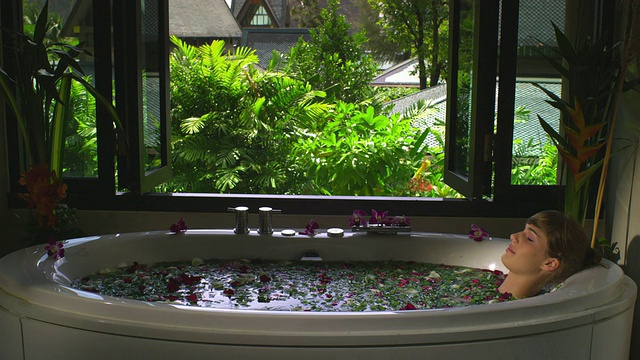 泰国甲米，女士在玫瑰花瓣温泉沐浴视频素材