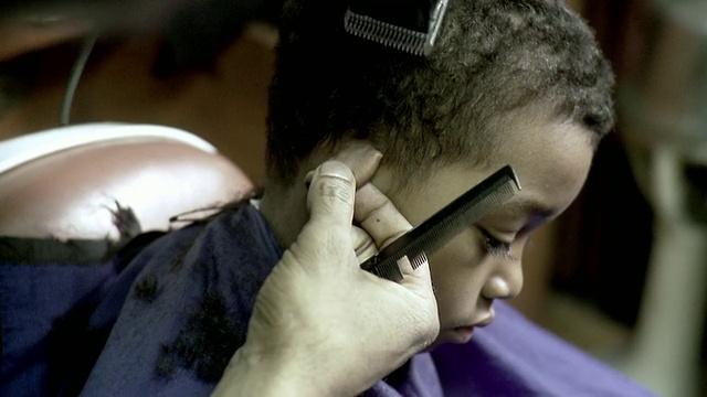 CU SELECTIVE FOCUS Barber在美国纽约州布鲁克林的一家理发店为男孩剃发(8-9)视频素材