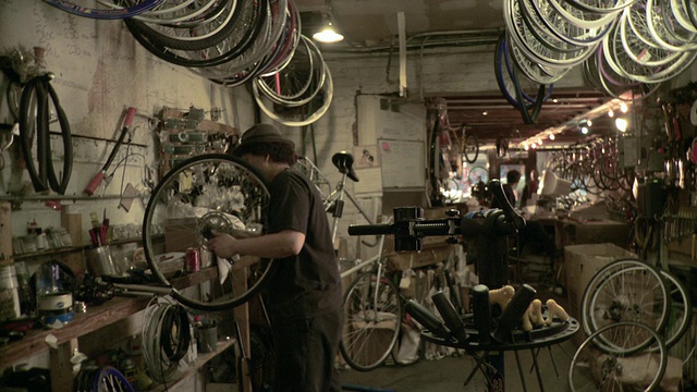 MS Man在美国纽约州布鲁克林市的自行车车间将旧自行车架安装到车架上，将车座拧到车座上视频下载